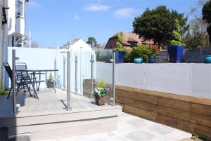 einen Balkon mit einem Tisch und einem Zaun in der Unterkunft Kingfisher Cottage in Sidmouth