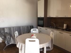 a kitchen with a table and chairs in a room at Casetta Girasole a due passi dal mare in Capilungo +20 photos