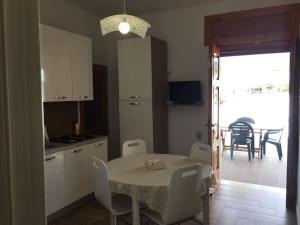 a kitchen and dining room with a table and chairs at Casetta Girasole a due passi dal mare in Capilungo