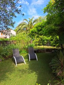 two chairs sitting in the grass in a garden at Villa Provençale à Mougins in Mougins