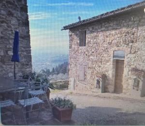 un edificio de ladrillo con un patio con mesas y sillas en Poggio Alla Pieve Relais en Calenzano