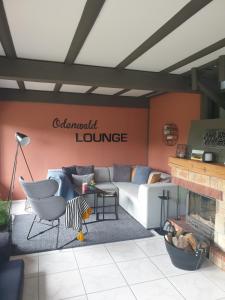 a living room with a couch and a fireplace at Odenwald Lounge - ehemals Ferienhaus Bergblick in Reichelsheim