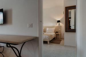 Habitación con cama, mesa y espejo. en Hotel Bougainvillier Djerba en Taguermess