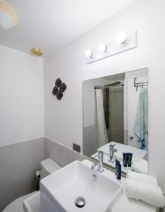 a white bathroom with a sink and a mirror at Wild Lotus Villa - Waterfront on Jolly Harbour in Bolans +31 photos