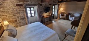 1 dormitorio con cama y pared de piedra en Habitaciones La Cuevona de Guitiriz Lugo en Guitiriz