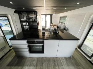 a kitchen with white cabinets and a black counter top at Island Harbour Houseboat in Newport