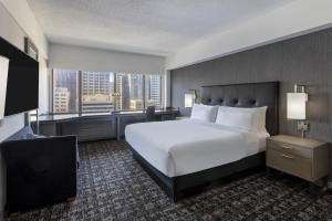 a bedroom with a large white bed and a large window at Hilton San Francisco Financial District in San Francisco