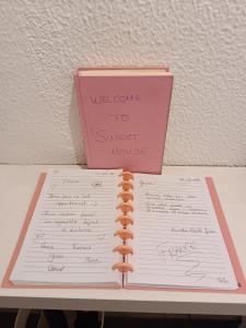 a notebook sitting on a table with a pink book at Sweet House in Lisbon