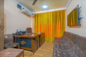 a conference room with a desk and a yellow curtain at Hotel Inabat Residency in Srinagar