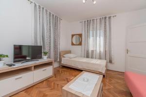 a living room with a television and a couch at Apartment Island Sun Terrace in Krapanj