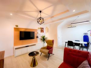 sala de estar con sofá, TV y mesa en Box Residence en Lagos