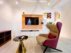 a living room with a chair and a tv at Box Residence in Lagos