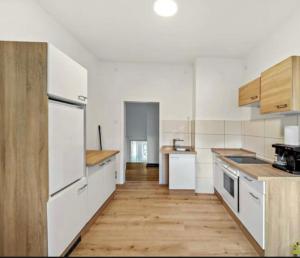 a kitchen with white appliances and a wooden floor at YveBeaRoe in Knittelfeld