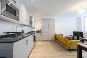een keuken met witte kasten en een gele bank bij Central Gloucester Getaway Retreat W/Free Parking 