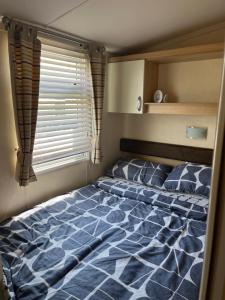 a large bed in a bedroom with a window at 21 Riverview, Allhallows in Rochester