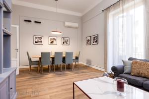 a living room with a table and chairs and a couch at Constance Luxury Apartment by DomuSicily in Palermo