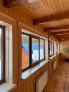 an empty room with windows in a wooden house at Під Явором in Vorokhta