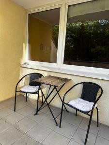 two chairs and a table in front of a window at Travel House Wroclaw in Wrocław