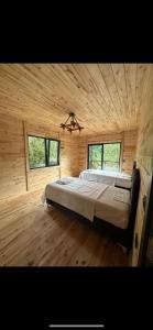 ein Schlafzimmer mit einem großen Bett in einer Holzhütte in der Unterkunft Mec konaklama in Trabzon