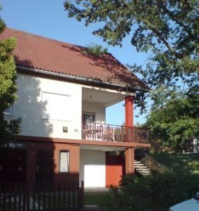ein weißes Haus mit einem Balkon und einem roten Dach in der Unterkunft Budai Garden House in Hévíz