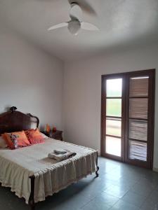 sypialnia z łóżkiem i wentylatorem sufitowym w obiekcie Casa em Condomínio tranquilo bem perto da praia! w mieście Saquarema