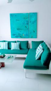 a living room with a green couch and a table at Cartagena primera línea de playa azul vista al mar 2 in Cartagena de Indias