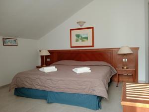 - une chambre avec un lit et 2 serviettes dans l'établissement Lucà Apartments, à Saluces