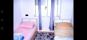 two beds in a room with two windows at Airport apartment 2 