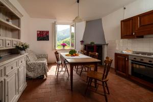 a kitchen with a table and chairs and a window at Val di Lima House in Cocciglia