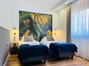 a hotel room with two beds and a painting on the wall at Apartamenty DELUXE-Willa DAHARA-Grupa PlażoweLove in Krynica Morska