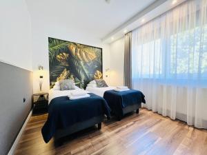 a bedroom with two beds and a large window at Apartamenty DELUXE-Willa DAHARA-Grupa PlażoweLove in Krynica Morska