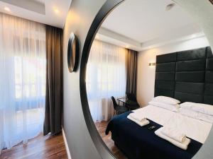 a bedroom with a bed and a mirror at Apartamenty DELUXE-Willa DAHARA-Grupa PlażoweLove in Krynica Morska