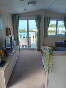 ニューキーにあるSuperb position 2 bedroom Caravan Newquay Walesのソファとテレビのあるリビングルーム