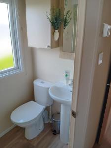ニューキーにあるSuperb position 2 bedroom Caravan Newquay Walesのトイレと洗面台付きのバスルーム +13枚の写真
