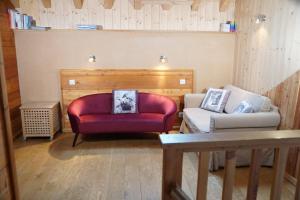 sala de estar con silla roja y sofá en Chalet Les Ecrins, en Villard-Reculas