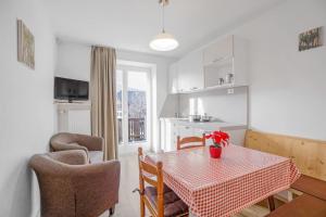 una cucina e una sala da pranzo con tavolo e sedie di Residence krUma a Valdaora