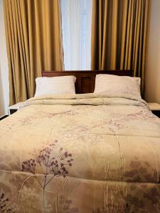 Un dormitorio con una cama con una colcha con flores. en treasury en Bagamoyo