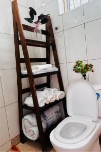 a bathroom with a toilet and a shelf with towels at treasury in Bagamoyo