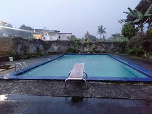 a chair sitting next to a swimming pool at Villa Ledenfi in Cisarua
