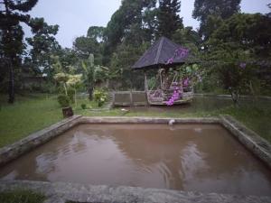 a pond in a garden with a gazebo at Villa Ledenfi in Cisarua
