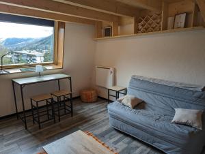 a living room with a couch and a window at Galibier studio in La Salle-les-Alpes