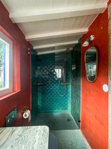 a bathroom with a shower with green tiles and red walls at Casa da Encosta - Hillside cabin near the sea in Colares