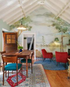 uma sala de jantar com um quadro na parede em Casa da Encosta - Hillside cabin near the sea em Colares