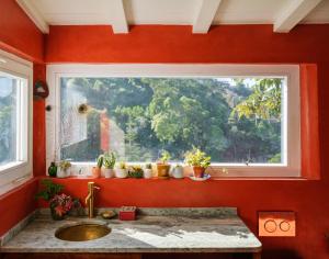 łazienka z umywalką i oknem z doniczkami w obiekcie Casa da Encosta - Hillside cabin near the sea w mieście Colares