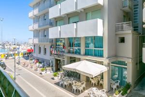 un condominio con tavoli e sedie su una strada di Hotel Europa a Gabicce Mare