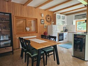 a kitchen with a wooden table and chairs in a kitchen at Holiday House Bella in Bihać