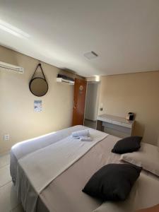 a bedroom with a large white bed with two pillows at Casa Lua in Brumadinho