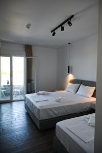 um quarto com 2 camas e uma varanda em Costa Varda Apartments em Mourteri