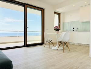 a kitchen and dining room with a view of the ocean at Le Conchiglie Residence in Porto Torres