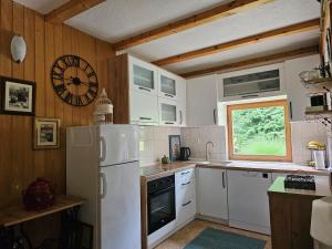 a kitchen with white appliances and a clock on the wall at Holiday House Bella in Bihać